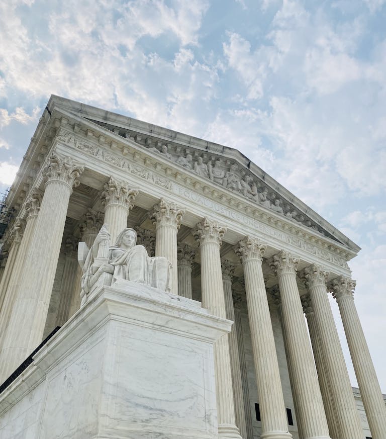 A low angle shot of the US Supreme Court showcasing its grandeur and architectural detail.